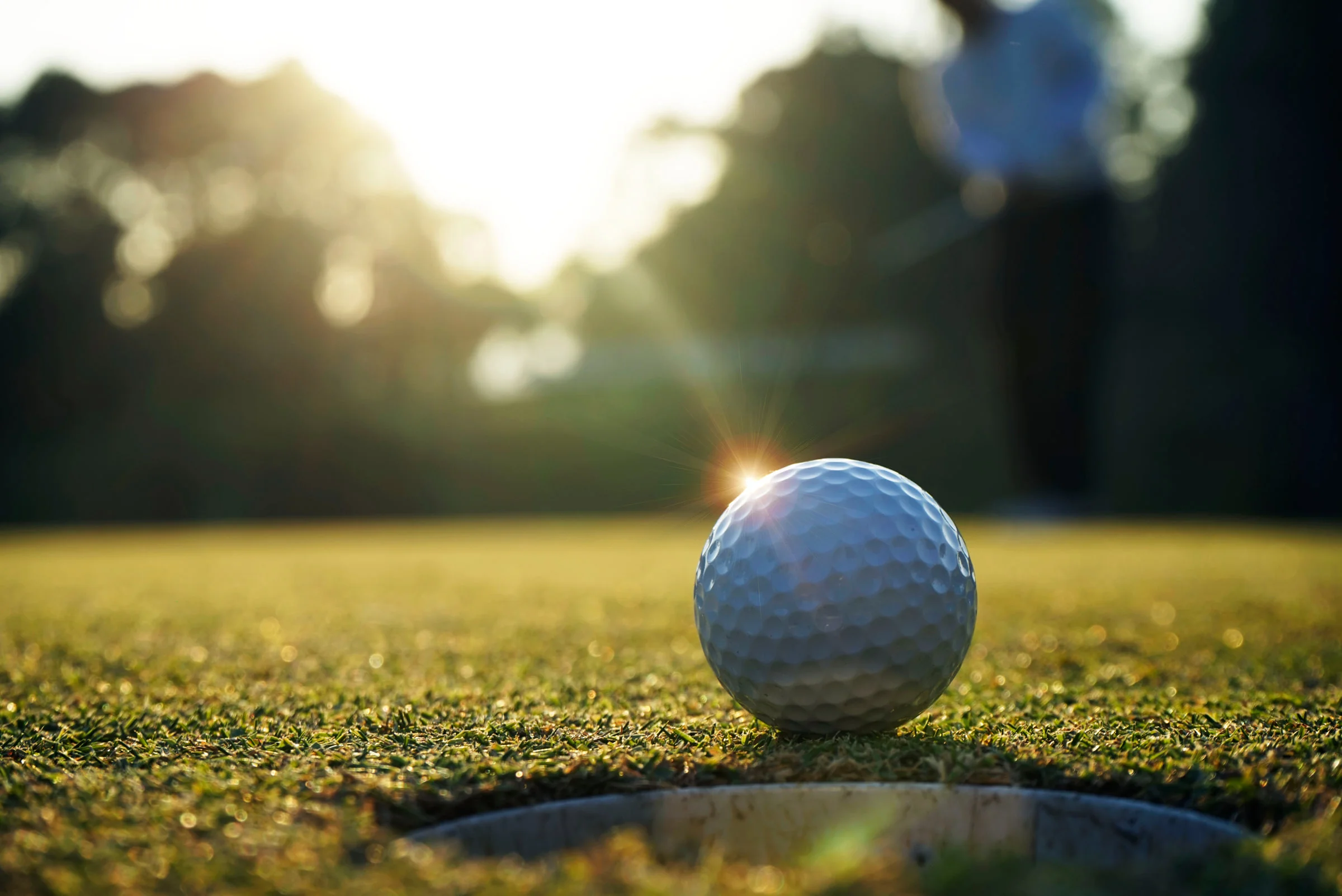Golfers on a sunny course during a tournament round.