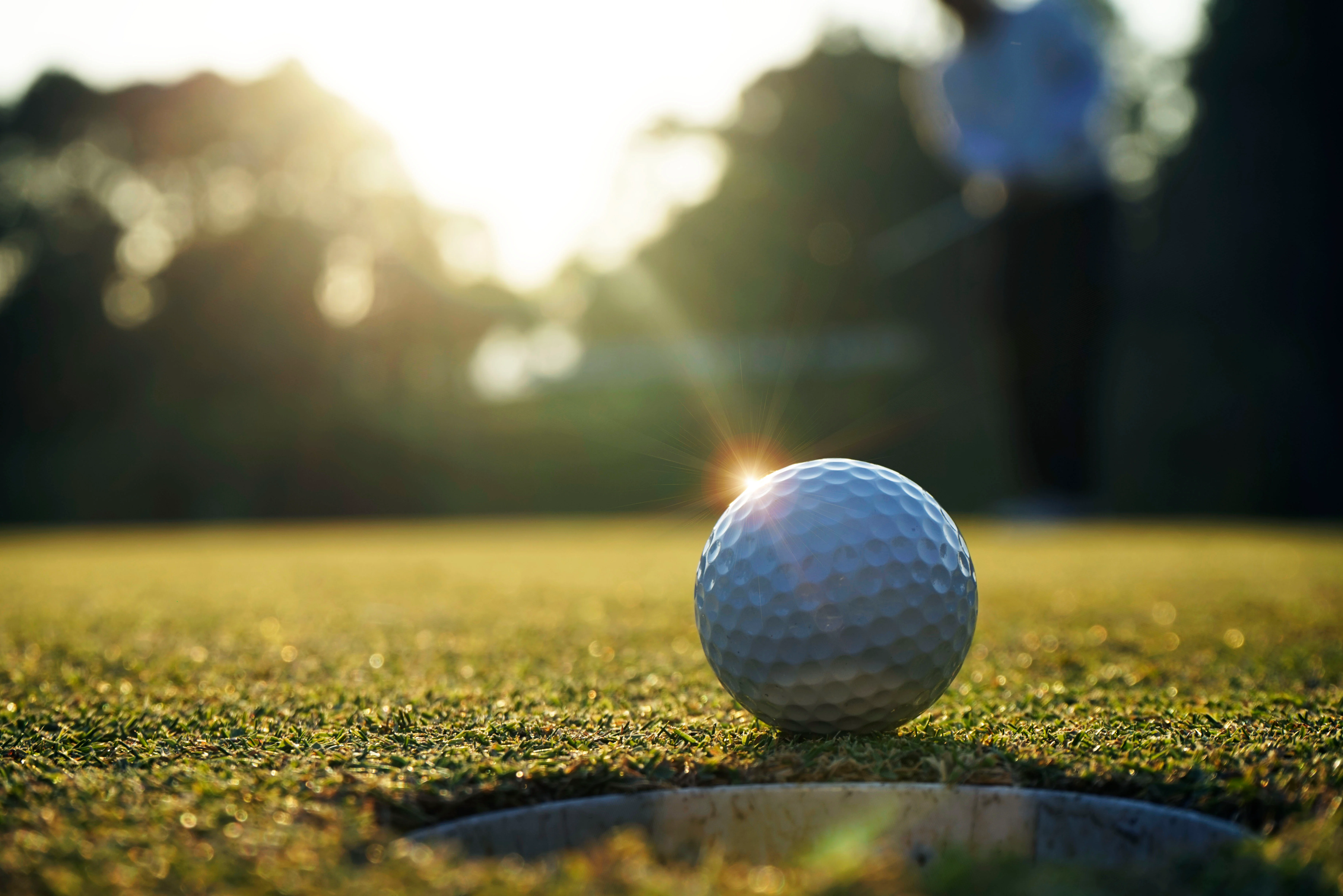 Golfers on a sunny course during a tournament round.