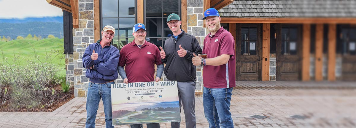 Male golfers posing for picture holding up a hole in one contest sign