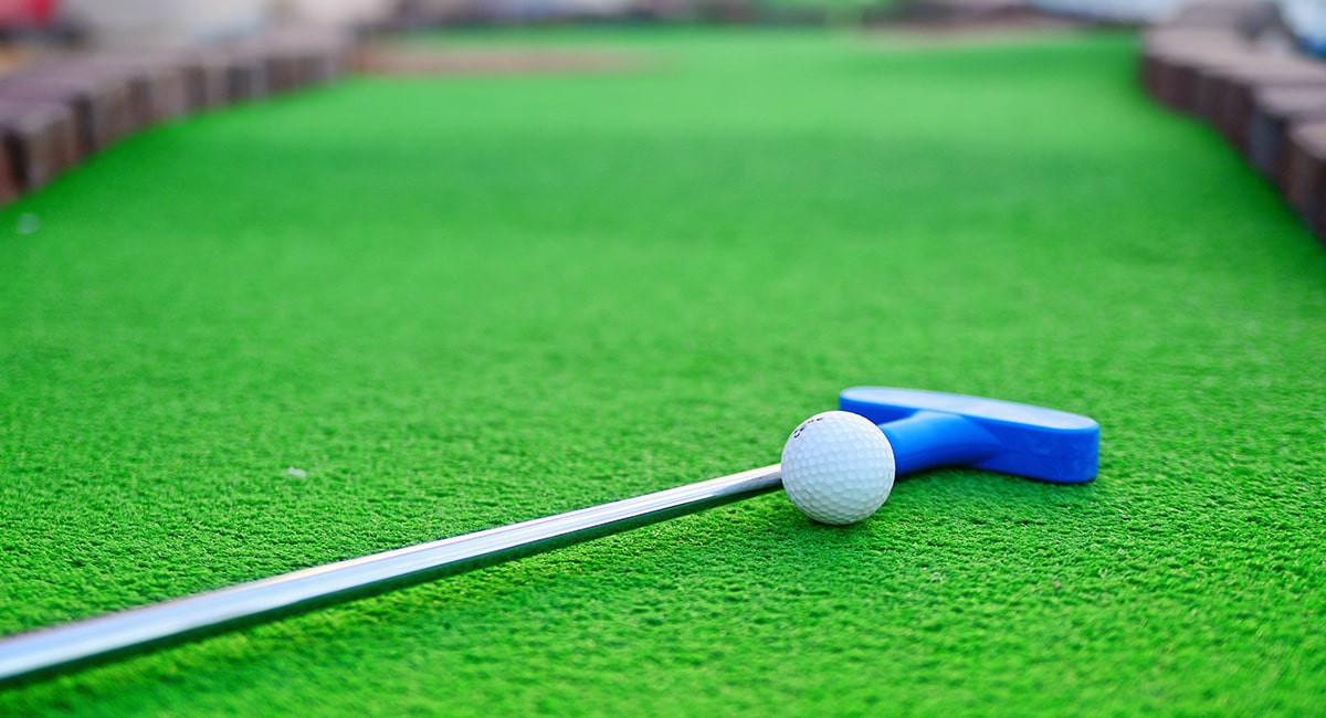 Putter and ball on green