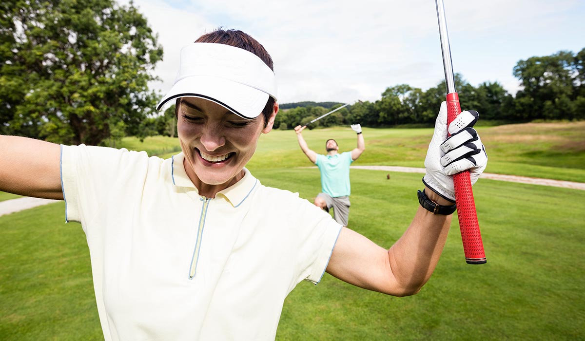 Woman golfer celebrating a hole in one 